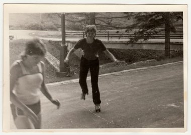 Retro photo shows girl who rides on roller skates . Black & white vintage photography. clipart
