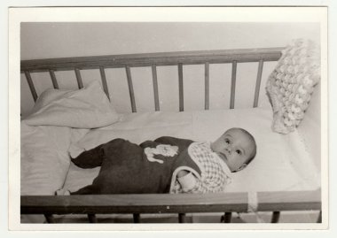 Retro fotoğraf bir yatakta yatıyor sevimli bebek gösterir. Siyah & beyaz vintage fotoğrafçılık.