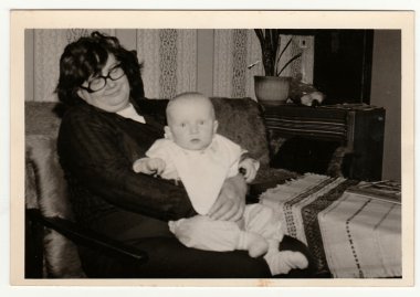Retro fotoğraf büyükanne küçük bir bebek beşik gösterir. Siyah & beyaz vintage fotoğrafçılık.
