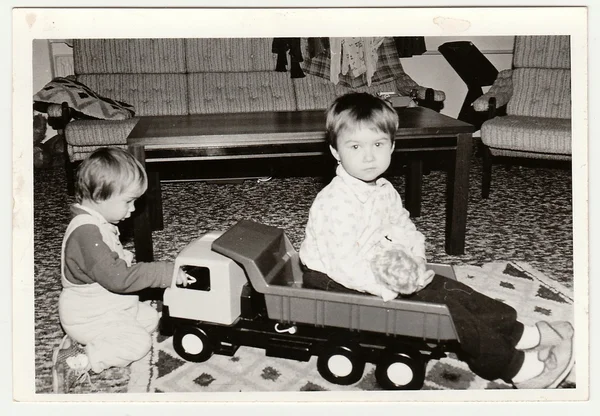 怀旧照片显示儿童谁玩玩具车。黑与白的老式摄影. — 图库照片