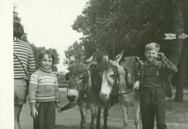 Retro fotoğraf eşekler çocuklarla parkta gösterir. Vintage siyah ve beyaz fotoğraf.