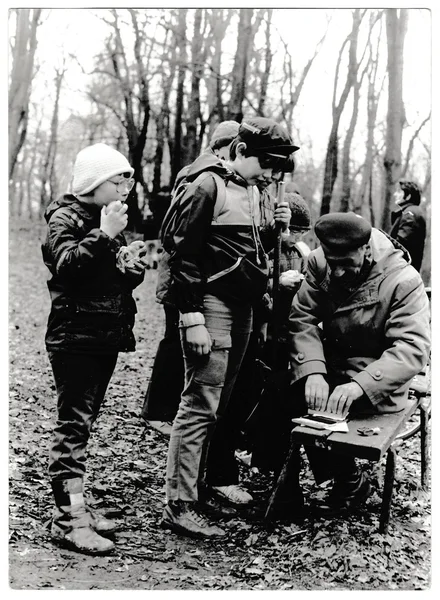 Foto retrò mostra giovani turisti e il loro capo nella foresta. Fotografia vintage in bianco e nero — Foto Stock