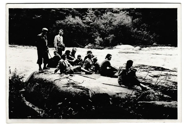 Foto retro mostra turistas têm um descanso na margem do rio. Preto & branco vintage fotografia . — Fotografia de Stock