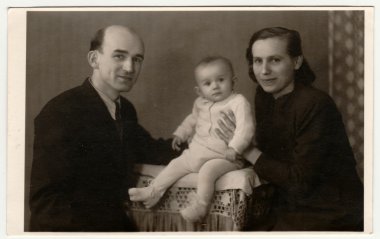 Retro fotoğraf yürümeye başlayan çocuk ailesiyle gösterir. Vintage siyah ve beyaz fotoğraf.