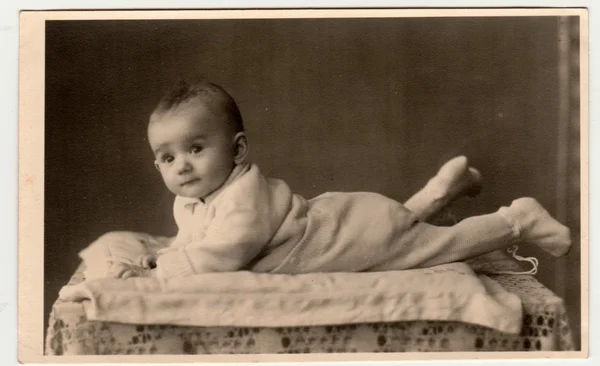 Retro photo shows toddler, lie prone. Vintage black & white photography. — Stock Photo, Image