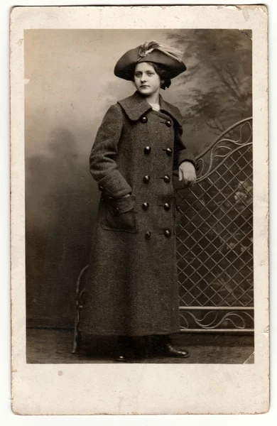 Вінтажні фотографії показують, що жінка носить жіночий капелюх і довгу горіхову куртку/довгу репелентну куртку. Ретро чорно-біла фотографія . — стокове фото