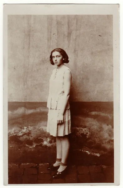 Foto de la vendimia muestra joven chica se para fuera. Lleva un vestido ligero. Fotografía en blanco y negro retro . — Foto de Stock