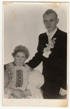 Vintage fotoğraf bir fotoğraf stüdyosunda çift gösterir. Kadın bir halk costum giyer. Retro black & white stüdyo fotoğrafçılığı.