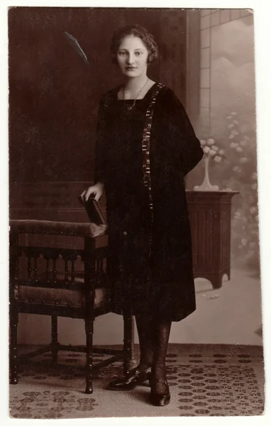 Foto vintage muestra a la mujer en un estudio de fotografía. Retro fotografía de estudio en blanco y negro con efecto sepia . — Foto de Stock