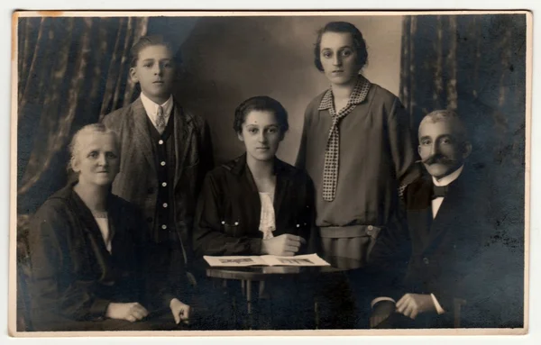 Vintage foto mostra la famiglia posa in uno studio di fotografia. Fotografia retrò in bianco e nero con effetto seppia . — Foto Stock