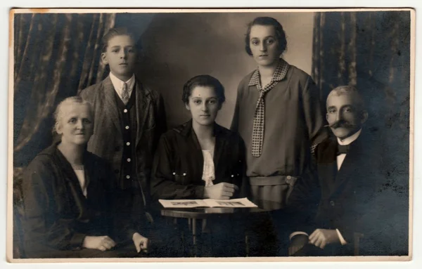 Foto vintage mostra poses de família em um estúdio de fotografia. Retro preto & fotografia estúdio branco com efeito sépia . — Fotografia de Stock