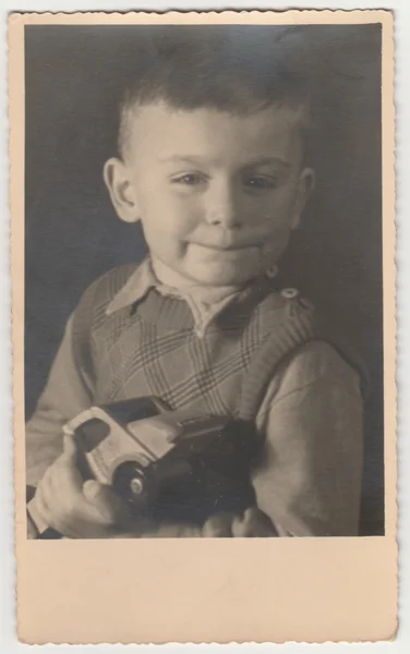 Vintage foto muestra niño sostiene coche de juguete. Fotografía en blanco y negro — Foto de Stock