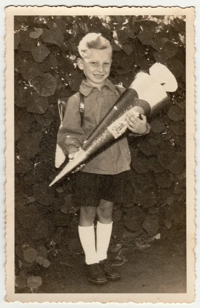 Vintage fotó azt mutatja, tanuló fiú a "Schultute" vagy a School Cone, édességek az első nap az iskolában. Stúdió fénykép szépia színárnyalatával. — Stock Fotó