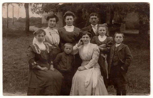 Ein historisches Foto zeigt Menschen, die im Garten posieren. Frauen mit edwardischen Frisuren. Retro Schwarz-Weiß-Fotografie. — Stockfoto