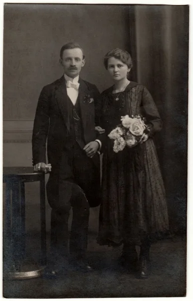 Vintage photo shows a couple in a photography studio. Retro black & white photography with sepia effect. — Stock Photo, Image