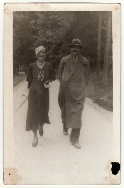 Винтажное фото показывает, как мужчина и женщина выходят на прогулку. Оригинальная ретро черно-белая фотография из фотоальбома. Без постпроцесса — стоковое фото