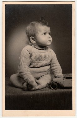 Vintage fotoğraf küçük bir çocuk gösterir - oyuncak araba ile yürümeye başlayan. Retro siyah & beyaz fotoğraf.