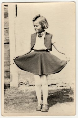 Vintage fotoğraf açık havada genç bir kız gösterir. Eteğini gururla gösteriyor. Retro siyah & beyaz fotoğraf.