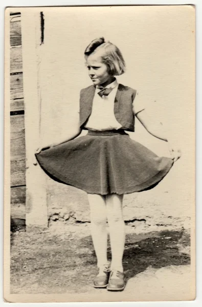 Vintage fotó azt mutatja, egy fiatal lány a szabadban. Azt mutatja meg szoknyáját büszkén. Retro fekete reggeli fehér fotózás. — Stock Fotó