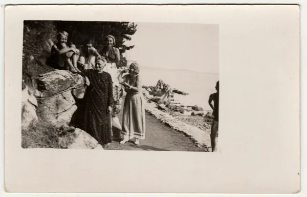 Jahrgangsfoto zeigt Menschen im Urlaub (Urlaub). Sie stehen am Ufer des Meeres. Retro Schwarz-Weiß-Fotografie. — Stockfoto