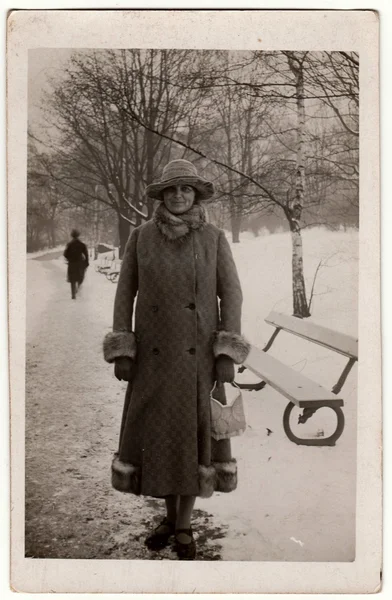 La foto vintage muestra a la mujer en invierno. La mujer lleva un abrigo largo con piel bordeando. Fotografía en blanco y negro retro . — Foto de Stock