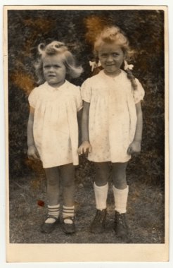 Vintage fotoğraf iki küçük kız (kardeşler) gösterir. Beyaz elbiseler giyiyorlar. Retro siyah & beyaz fotoğraf.