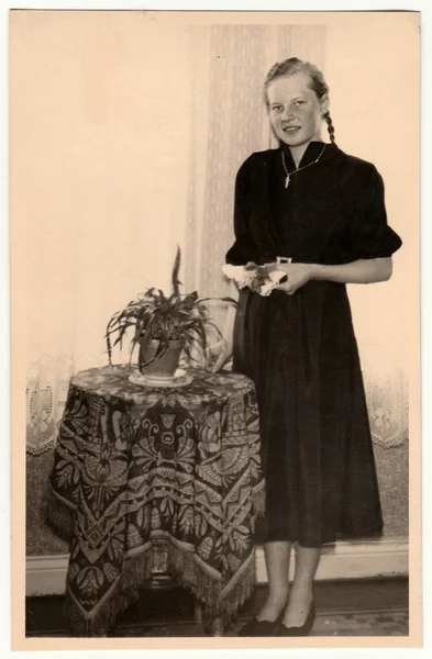 Foto vintage muestra a una joven posando en la mesa de la sala de estar. Fotografía en blanco y negro retro . — Foto de Stock