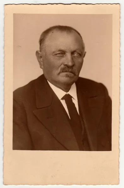 Vintage photo shows portrait of an elderly man. Retro black & white studio photography with sepia effect. — Stock Photo, Image