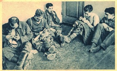 EAST EUROPE - 1944: German war prisoners in time of silence. Time for repairing of clothes. German soldiers in POW camp. clipart