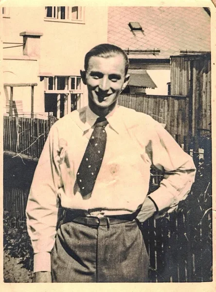 Foto vintage mostra homem dandy posar no quintal. O homem usa gravata e camisa branca. Retrato preto e branco antigo. Por volta de 1920 — Fotografia de Stock