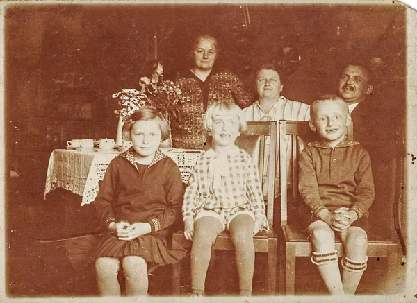 Foto vintage mostra família e mesa festiva. Sepia fotografia em preto e branco. Por volta dos anos 30 — Fotografia de Stock