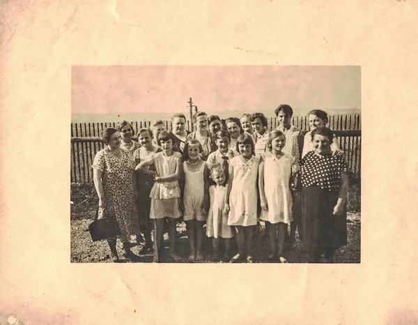 1950年代的Circa 复古照片显示一群人在后院休息 大部分是照片上的妇女和女孩 亲属群体 — 图库照片