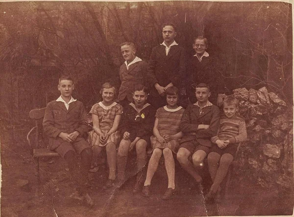 Foto vintage mostra grupo de jovens posar ao ar livre. Foto com efeito sépia. — Fotografia de Stock