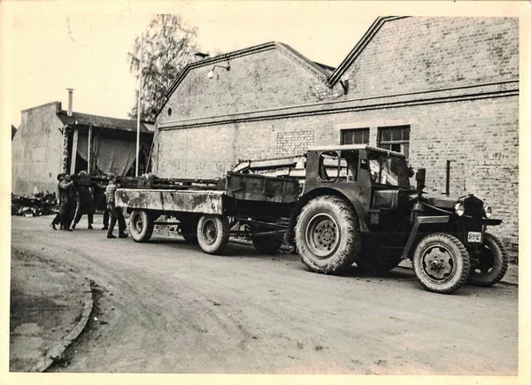 FRAUREUTH, EAST GERMANY - 15 Mayıs 1965: Retro fotoğraf gösterileri işçilerin karavana kabarık inşaat yüklediğini gösteriyor. Eski Sosyalist blokta 1960 'ların traktörü.