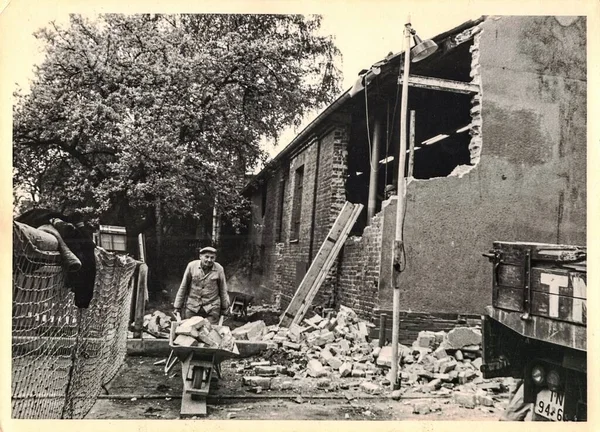 FRAUREUTH, EAST GERMANY - 21 Mayıs 1965: Komünist bloktaki retro fotoğraf sitesi gösteriyor. İnşaat alanında tuğla ustası. Eski Doğu Almanya, 1960 'lar.