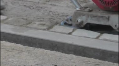 Plaka sıkıştırıcısını kapat. Bina işçisi plaka sıkıştırıcıyı yönetiyor