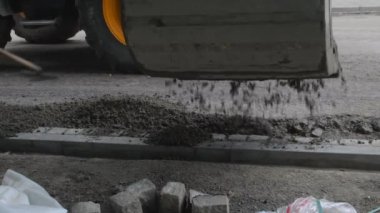 Elektrik küreği inşaat alanına ıslak beton döküyor. Yol bitiricisinden önce son iş