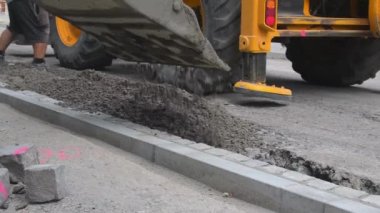 Elektrik küreği inşaat alanına ıslak beton döküyor. Yol bitiricisinden önce son iş