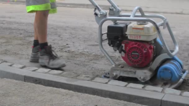 Close-up of plate compactor. Building worker leading the plate compactor — Stock Video