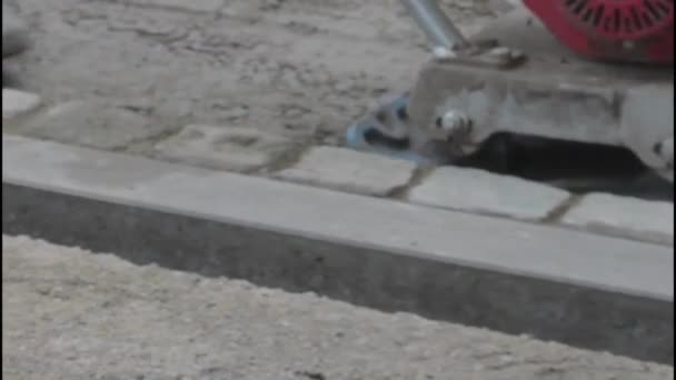Zbliżenie zagęszczarki talerzy. Pracownik budowlany prowadzący zagęszczarkę płyt — Wideo stockowe
