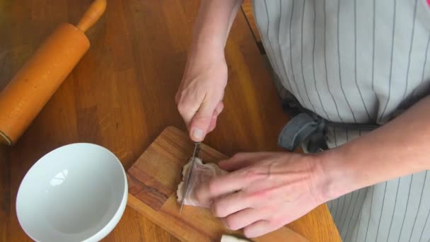 El chef corta un trozo de tocino en cubos con un cuchillo afilado en la tabla de madera. Vista de ángulo alto — Vídeo de stock