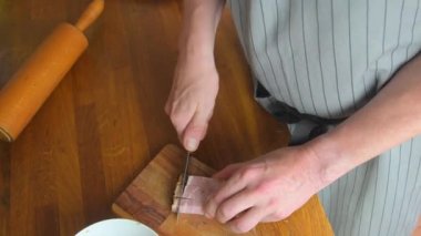 Erkek aşçı ya da aşçı pastırmayı bir restoranda ya da evde tahta kesme tahtasıyla küçük küplere ayırıyor. Yüksek açı görünümü