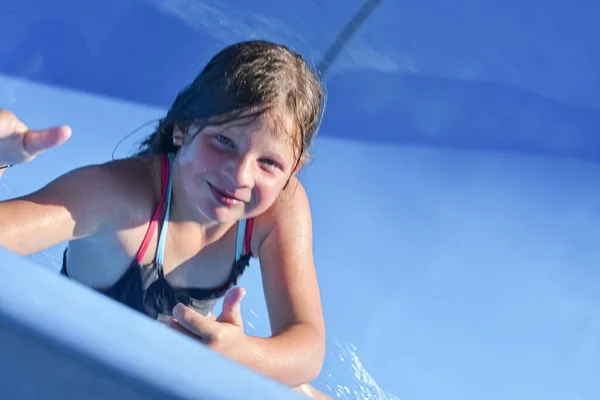 Ευτυχισμένο παιδί σε νεροτσουλήθρα στο θαλάσσιο πάρκο. νεροτσουλήθρα με τρεχούμενο νερό στο aqua park. Καλοκαιρινές διακοπές στο πάρκο. Έννοια διακοπών — Φωτογραφία Αρχείου
