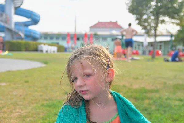 Una ragazzina stanca al parco acquatico. Stanchezza estiva. Concetto di disidratazione — Foto Stock