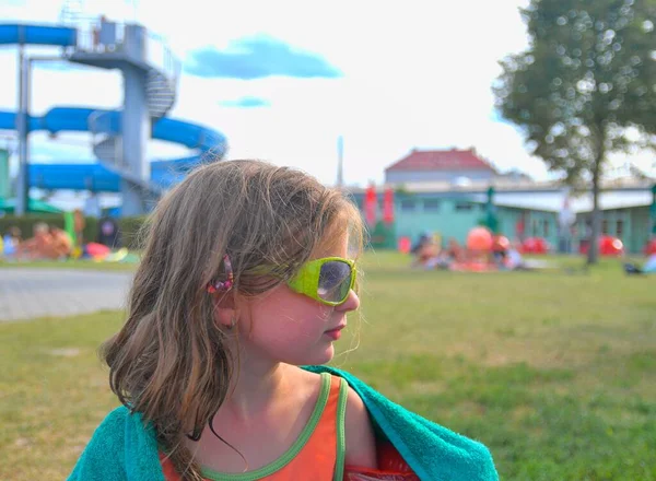 Klein gelukkig meisje met een zonnebril op vakantie. Zonnige warme zomerdag, reisconcept — Stockfoto