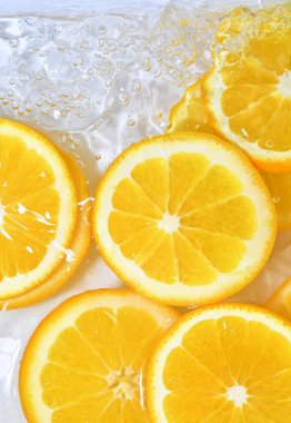 Beyaz arka planda sulu portakallı taze dilimler. Beyaz arka planda köpüklü suyla portakal dilimleri, yakın plan. Citrus sodası. Boşluğu kopyala