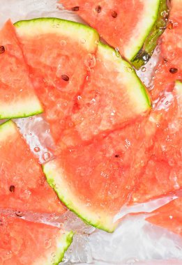 Limonata arka planındaki kırmızı kavun dilimlerinin yakın görüntüsü. Serinletici tatlı yazların dokusunda cam duvarda makro kabarcıklar olur. Düz tasarım