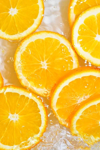 Vista de perto das fatias de laranja para fundo de limonada. Textura de arrefecer verões doces beber com bolhas macro na parede de vidro. Projeto plano — Fotografia de Stock