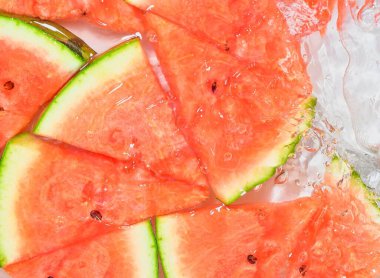 Baloncuklu karpuz sıvısı. Suda olgun kırmızı kavun dilimleri. Beyaz arka planda taze kırmızı kavun dilimleri.