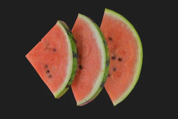 Nakrájený meloun na černém pozadí. Kousky melounu izolovaného na černém pozadí. Plocha — Stock fotografie